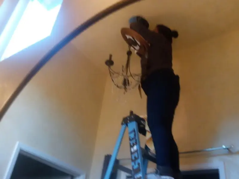 Electrician installing a chandelier in a Santa Maria residence